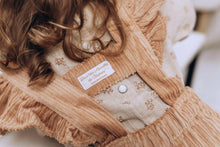 Charger l'image dans la galerie, Blouse bébé fille Flora en double gaze de coton lin beige à fleurs corail et jupe à bretelles volantées en velours côtelé vieux rose durable et écoresponsable fabriquées en France par Les p'tites Merveilles de Bérénice portées par Charlie 24 mois