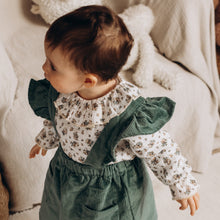 Charger l'image dans la galerie, Blouse bébé fille Flora en double gaze de coton Biologique blanc et vert à fleurs et jupe à bretelles volantées en velours côtelé coton Biologique vert émeraude durable et écoresponsable fabriquée en France par Les p'tites Merveilles de Bérénice portée par Suzanne 14 mois