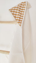 Charger l'image dans la galerie, Cape de bain bébé vichy moutarde et blanc en coton BIO éponge nid d'abeille écru et popeline de coton fabriquée en France par Les p'tites Merveilles de Bérénice